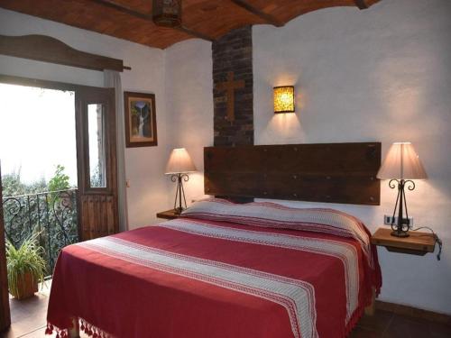 a bedroom with a large red bed with two lamps at Hotel Mi Pueblito Tapalpa in Tapalpa
