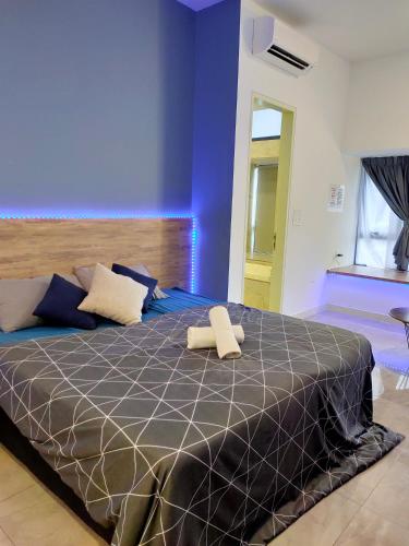 a bedroom with a large bed with a blue wall at Imperio Residence Bathtub Studio at Malacca Town-Near JONKER STREET in Melaka