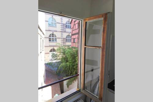 una ventana abierta con vistas a un edificio en Appartement cosy rue Sainte Madeleine, en Estrasburgo
