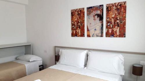 een slaapkamer met een bed en 2 posters aan de muur bij Cabà Holiday Bardolino Colombo in Bardolino