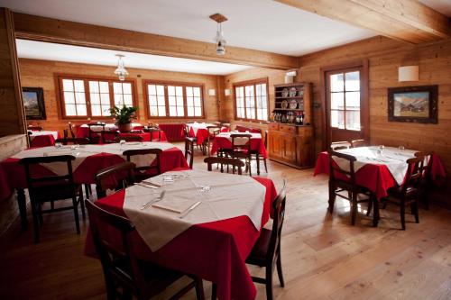 a dining room with tables and chairs with red table cloth at B&B La Locanda in Macugnaga
