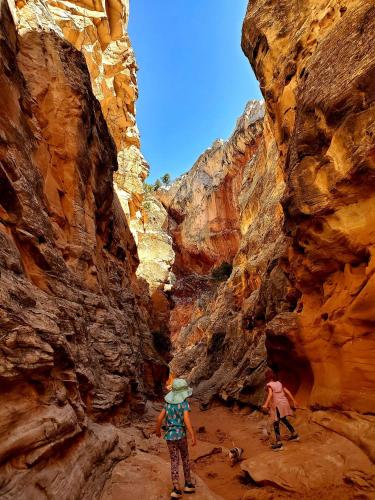 two people are walking through a canyon at Kanab Suites in Kanab