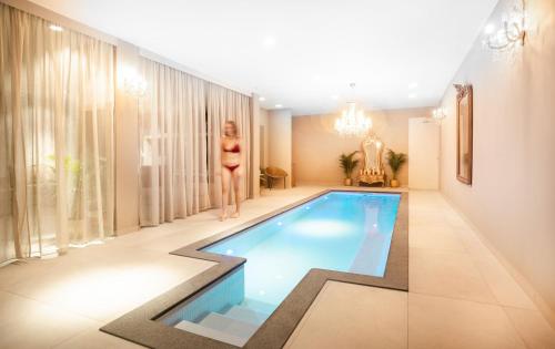 a woman in a bikini standing next to a swimming pool at Sé Boutique Hotel in Funchal