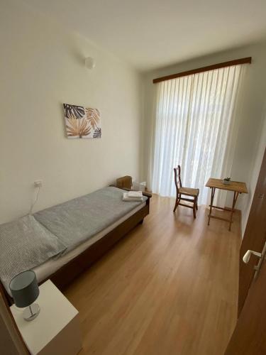 a bedroom with a bed and a table and a chair at Hotel Bellavista Cavigliano in Cavigliano