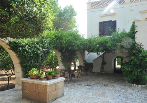 an outdoor patio with a table and chairs and plants at Antica Casina B&B di Charme in Pulsano