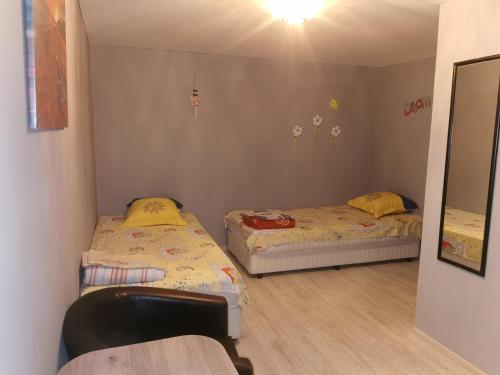 two beds in a small room with a mirror at casa la meduza in Vama Veche