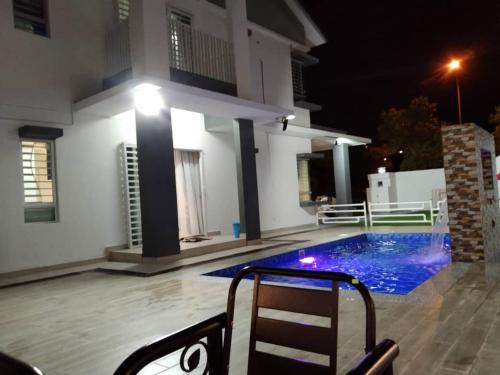 汝来Villa with private Pool and Sauna @ Nilai的晚上有游泳池的房子