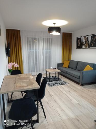 a living room with a couch and a table at Apartament Mazury Węgorzewo in Węgorzewo