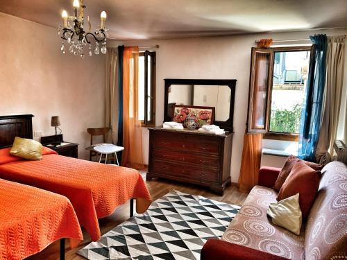 a bedroom with a bed and a dresser and a mirror at Grimaldi Apartments San Marco & Castello in Venice