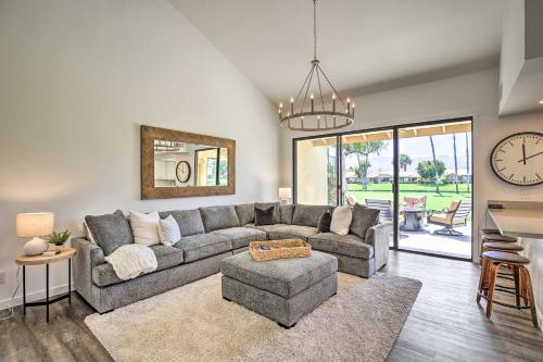a living room with a gray couch and a clock at Palm Desert Escape with Patio, Grill and Fire Pit in Palm Desert