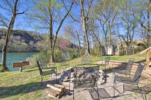 a fire pit in a park with chairs and a lake at Expansive Cotter Cabin on White River with Deck! in Cotter