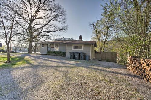 a white house with a fence and a driveway at Expansive Cotter Cabin on White River with Deck! in Cotter
