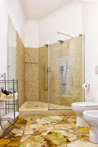 a bathroom with a shower and a toilet and a sink at Il Giardino Di Flora con Piscina & Jacuzzi in Lecce