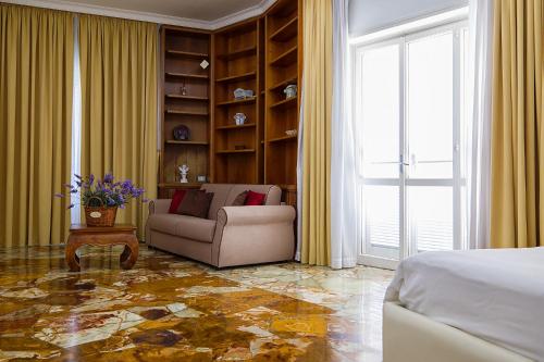 a bedroom with a bed and a couch and a window at Il Giardino Di Flora con Piscina & Jacuzzi in Lecce