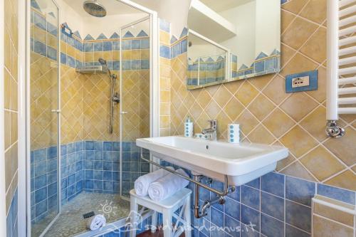 un baño con lavabo y ducha en CASA CON VISTA MARE, en Cala Gonone