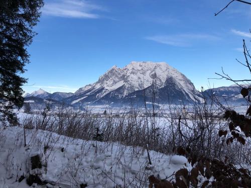 a mountain covered in snow in front of a field at Amtmannhaus Ferienunterkunft in Irdning