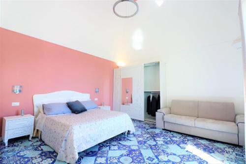 a bedroom with a bed and a couch at Mary's Apartments - De Vivo Realty Massa Lubrense in Massa Lubrense