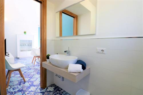 a bathroom with a white sink and a mirror at Mary's Apartments - De Vivo Realty Massa Lubrense in Massa Lubrense