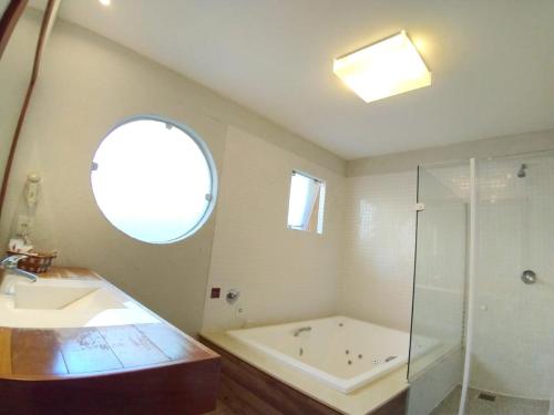 a bathroom with a tub and a sink and a shower at Rio Búzios Boutique Hotel in Búzios
