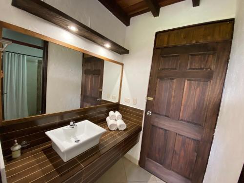 a bathroom with a sink and a wooden door at Finca Hotel La Esperanza in Montenegro