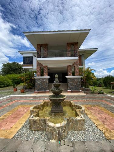 a house with a fountain in front of a building at Finca Hotel La Esperanza in Montenegro