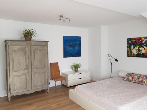 - une chambre avec un lit, une armoire et une chaise dans l'établissement MAISON DES FLEURS, à Bruxelles