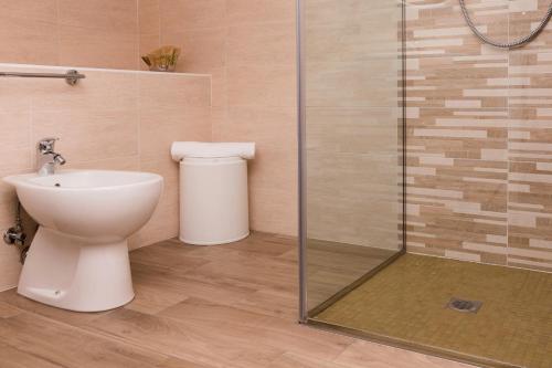 a bathroom with a toilet and a glass shower at Hotel Lydia in Cervia