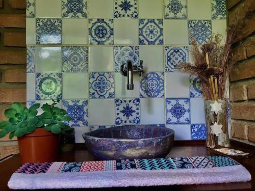 a bathroom with a sink and blue and white tiles at Hospedagem EXCALIBUR in Visconde De Maua