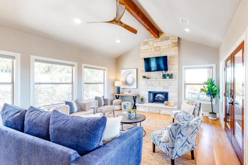 a living room with blue couches and a fireplace at Lago Vista Retreat in Lago Vista