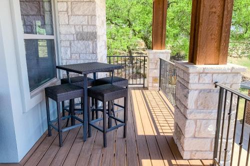 a porch with a table and two stools on a deck at Lago Vista Retreat in Lago Vista
