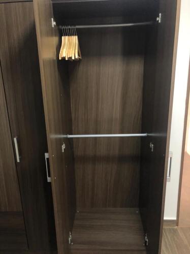a closet with a wooden door with a broom at Hostal Lucy in Valledupar