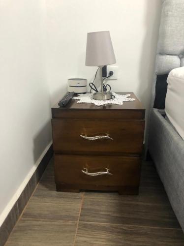 a nightstand with a lamp on it next to a bed at Hostal Lucy in Valledupar