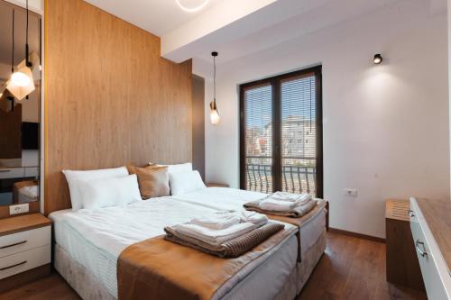 a bedroom with a large bed with towels on it at Blue Lake Apartments in Ohrid