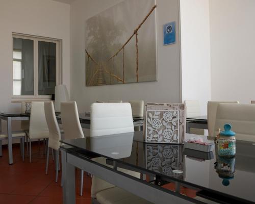 a dining room with a glass table and white chairs at Il Giardino Di Flora con Piscina & Jacuzzi in Lecce
