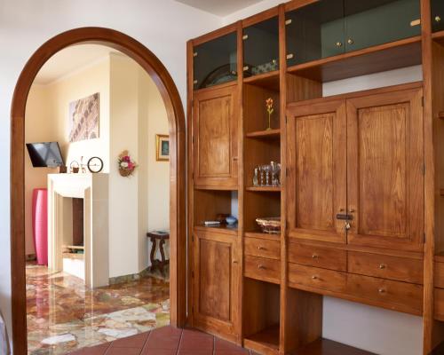 an archway leads into a room with wooden cabinets at Il Giardino Di Flora con Piscina & Jacuzzi in Lecce