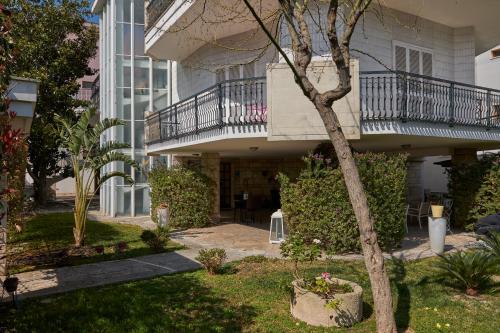 an apartment building with a balcony and a yard at Il Giardino Di Flora con Piscina & Jacuzzi in Lecce
