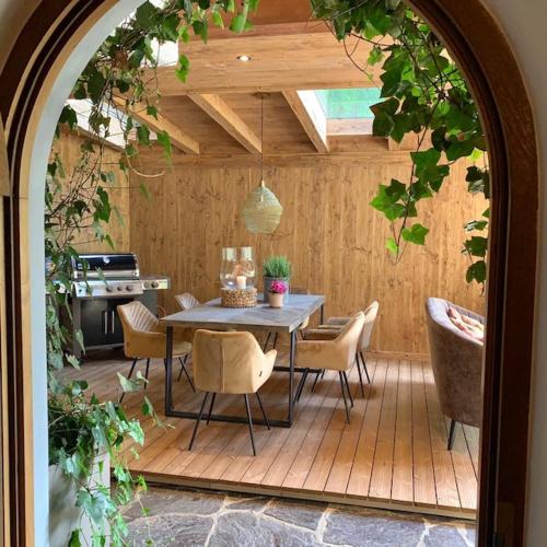 a patio with a table and chairs and a kitchen at Gästehaus Weiherhof in Alpbach