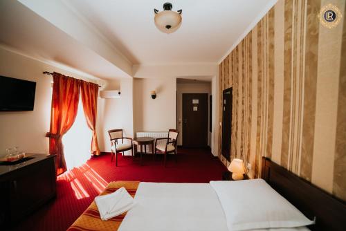 a hotel room with a bed and a table at La Rezidenta in Sibiu