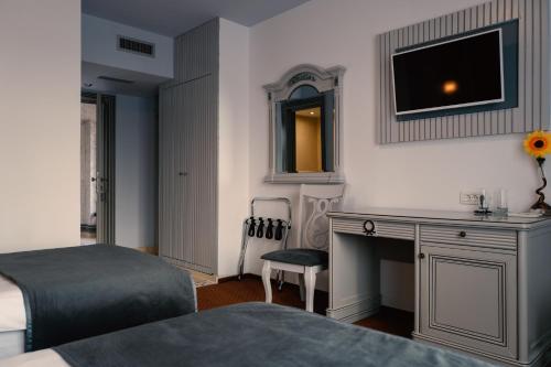 a bedroom with two beds and a desk and a television at Hotel Eden in Iaşi