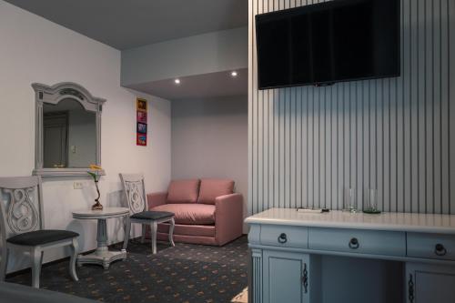 een woonkamer met een bank en een tv bij Hotel Eden in Iaşi