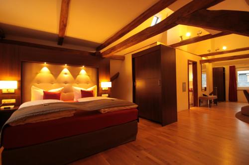 a bedroom with a large bed with lights on it at Boutique Hotel Villa Melsheimer in Reil