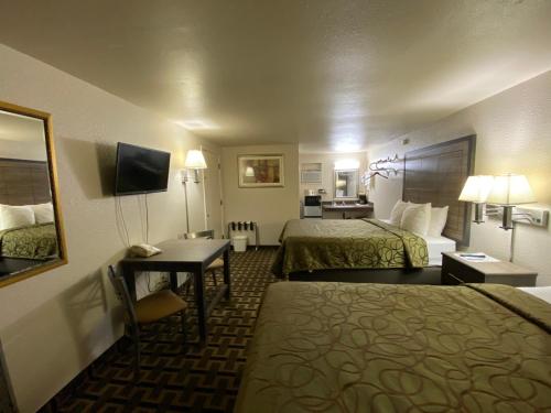 a hotel room with two beds and a desk at Motel In The Pines in Munds Park