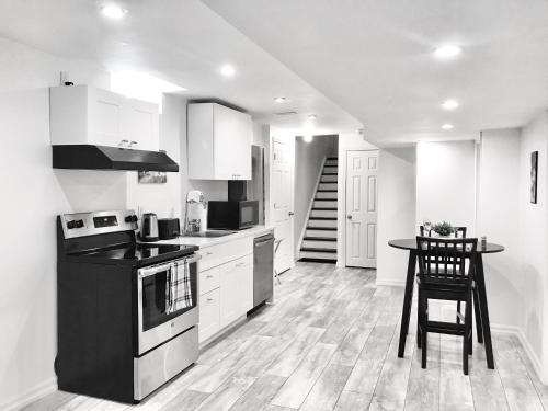 uma cozinha em preto e branco com uma mesa e um fogão em Modern 1BR Basement Suite With Parking em Innisfil