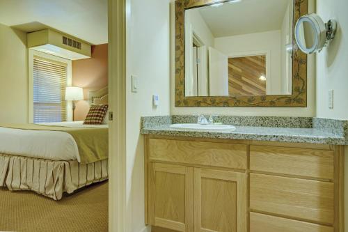a bathroom with a sink and a bed and a mirror at Seventh Mountain Resort in Bend