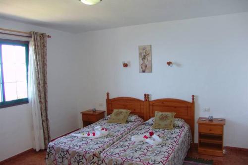 ein Schlafzimmer mit einem Bett mit weißen Handtüchern darauf in der Unterkunft Apartamentos Finca Casa Jardín in Tijarafe