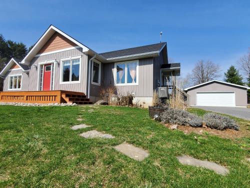 una casa con una porta rossa e un cortile di Bizlodge County Greenside Lakeview a Deseronto