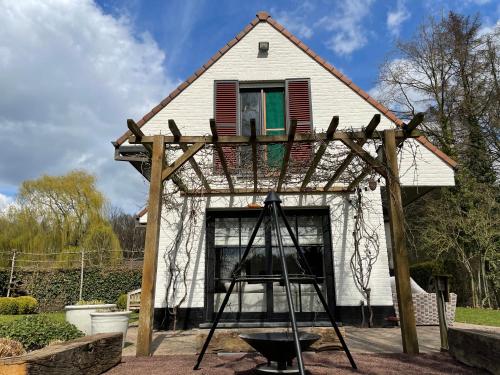 une maison construite avec une échelle devant elle dans l'établissement No Tempo, à Knesselare