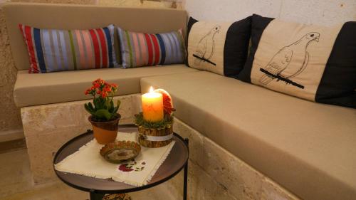 a candle on a table next to a couch at Pigeon Hotel Cappadocia in Uchisar