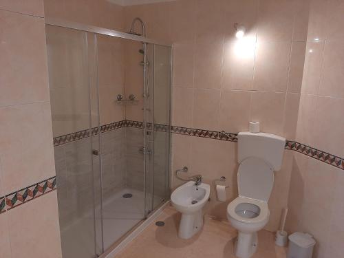a bathroom with a toilet and a glass shower at Dunas do Alvor 239 one bedroom in Alvor