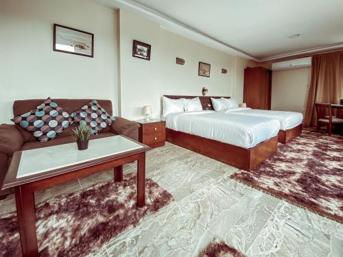 pokój hotelowy z 2 łóżkami i kanapą w obiekcie Pyramids Musem Apartment w Kairze
